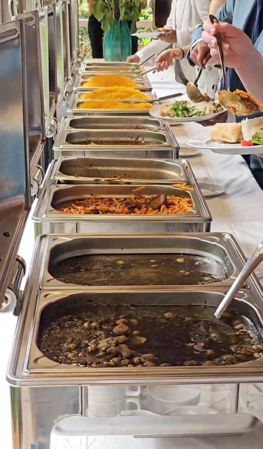Catering-Buffet mit Warmhaltebehältern, Safran-Reis und Schmorgerichten
